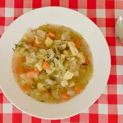Aromaticzna zupa ze słodkiej kapusty z ziemniakami i marchewką, posypana świeżym koperkiem.
