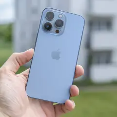 Niebieski iPhone 13 Pro z potrójnym aparatem w dłoni, gotowy do uchwycenia pięknych chwil.