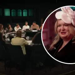 Uczestnicy programu "Zdrajcy" siedzą przy okrągłym stole. W zbliżeniu kobieta w białym kapeluszu z kwiatem.