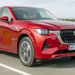 Czerwona Mazda CX-60 na drodze, podczas testu. Kierowca w kabinie.