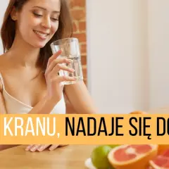 Uśmiechnięta kobieta pije wodę z kranu, zastanawiając się nad obecnością mikroorganizmów w wodzie pitnej.