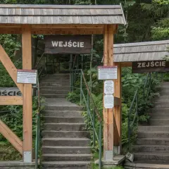 Kamienne schody prowadzą do wejścia na Szczeliniec Wielki. Drewniane zadaszenia i tablice informacyjne zapraszają do zwiedzania.