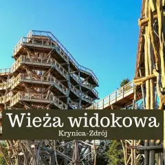 Drewniana wieża widokowa w Krynicy-Zdroju wznosi się ku błękitnemu niebu, oferując wspaniałe widoki na okolicę.