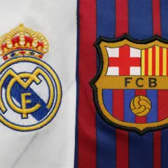 Emblematy Realu Madryt i FC Barcelony obok siebie. Kto jest lepszy, Real czy Barca? Odwieczna rywalizacja na koszulkach.