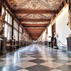 Corridoio della **Gallerie des Offices Florence**, con statue classiche, soffitto affrescato e pavimento a scacchi.