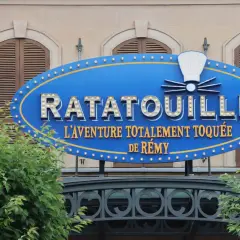 Panneau bleu lumineux de Ratatouille, l'aventure totalement toquée de Rémy, devant un bâtiment.