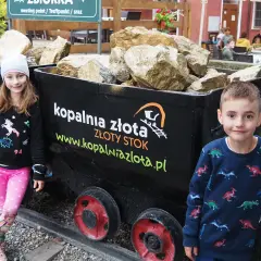 Dzieci przy wagonikach z "złotem" w Kopalni Złota w Złotym Stoku. Atrakcje dla całej rodziny.
