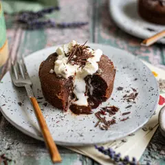 Ein Schokoladen-Lava-Kuchen mit flüssigem Kern, garniert mit Schlagsahne und Schokostreuseln. Ein perfektes Lava cake rezept für Genießer.