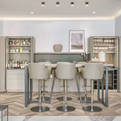Modern bar area with sleek bar stools. The question of whether bar stools should match dining chairs is answered by this elegant setup.