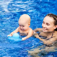 Mama z niemowlakiem w basenie. Po kąpieli można wyjść na dwór z niemowlakiem, gdy jest ciepło i dziecko jest dobrze osuszone.