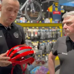 Wojtek prezentuje czerwono-czarny kask rowerowy.