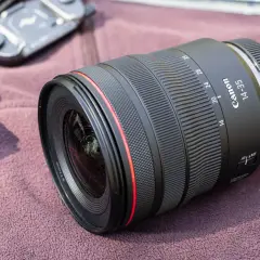 Obiektyw Canon 14-35mm, idealny do krajobrazu, leży na miękkim materiale.