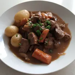 En härlig fransyska gryta med möra köttbitar, mjuka potatisar och saftiga morötter, toppad med färsk persilja.