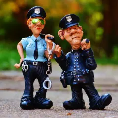 Dwie figurki policjantów, jeden z kajdankami, drugi z miną sugerującą, że trzeźwy poranek to podstawa prawna.