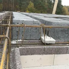 Budowa domu: betonowe pustaki i zbrojenie pod nadproże. Poduszka betonowa pod nadproże zapewnia stabilne podparcie.
