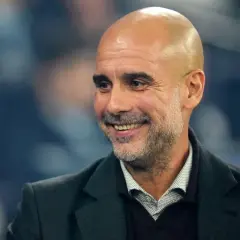 Uśmiechnięty Pep Guardiola, trener Manchesteru City, omawia najnowsze manchester city transfery.