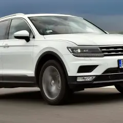 Biały Volkswagen Tiguan 2 jedzie po drodze.