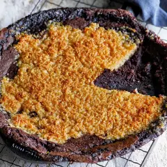 En kladdkaka med kokostosca, med en härlig seg chokladbotten och ett gyllene, krispigt kokostäcke.