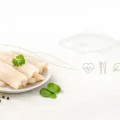 Filety z mintaja na talerzu z cytryną i ziołami. Czy mintaj jest zdrowy? Tak, to ryba pełna białka i omega-3.