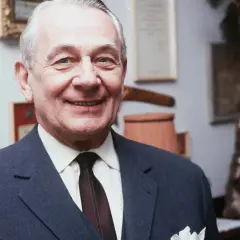 Uśmiechnięty Mieczysław Fogg w garniturze, z medalem na ścianie. Czy to jego podwójne życie?