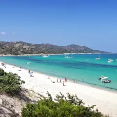 Piękna plaża Pampelonne z turkusową wodą, białym piaskiem i łodziami na horyzoncie.