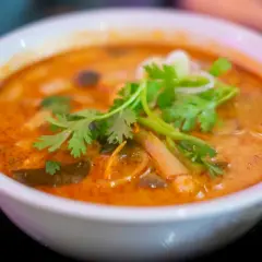 Aksamitna zupa tom yum z krewetkami, grzybami i świeżą kolendrą. Aromatyczny, pikantny bulion zachęca do spróbowania.