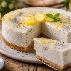 Köstlicher Kuchen ohne Backen mit Zitronen-Mohn-Geschmack, garniert mit frischen Zitronenscheiben und Minze.