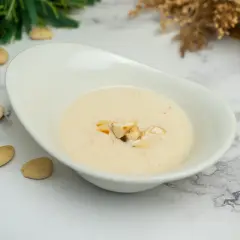 Crema suave y sedosa, una deliciosa salsa de almendras, decorada con trozos de almendra tostada.