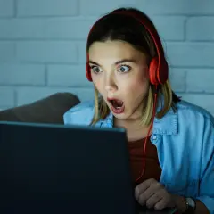 Zaskoczona dziewczyna w słuchawkach gra w escape gry online.