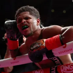 Boxer with green mouthguard grimaces, ready to deliver a powerful counter jab.
