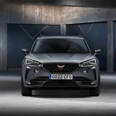 Szary SUV z charakterystycznym logo na grillu. To Cupra, jaka to marka? Sportowy design i nowoczesne linie.