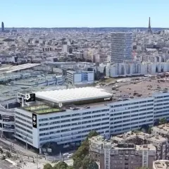 Vue aérienne de Paris, avec le complexe sportif Le Five Paris 18 sur le toit d'un immeuble.