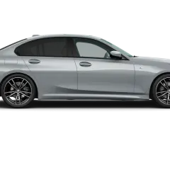 Profilo laterale di una BMW Serie 3 2026 grigio metallizzato, con cerchi in lega sportivi e finestrini oscurati.