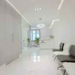 Nowoczesne wnętrze poczekalni kliniki dermatologii estetycznej z recepcją i wygodnymi fotelami.
