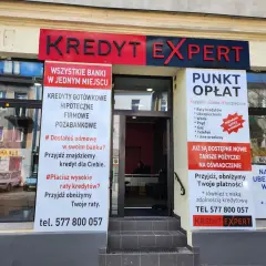 Elewacja biura Kredyt Expert z banerami informującymi o usługach kredytowych i opłatach.