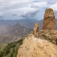 Majestatyczne skały Roque Nublo na Gran Canaria, z turystami podziwiającymi krajobraz.