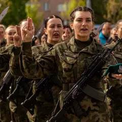 Żołnierze w mundurach, z karabinami i bagnetami, składają przysięgę. To obraz z ćwiczeń dobrowolnej zasadniczej służby wojskowej.