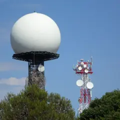 Duża biała kopuła, prawdopodobnie najlepszy radar pogodowy, góruje nad wieżą telekomunikacyjną.