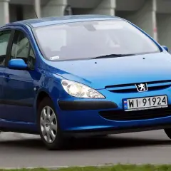 Niebieski Peugeot 307 2.0 HDI z polskimi tablicami WI 91924 jedzie po drodze.