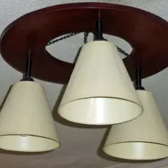 Lámpara de techo de madera oscura con tres pantallas cónicas color crema. Ideal para aprender como hacer una lampara de techo.