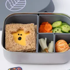 A spooky Halloween bento box with a ghost-shaped cheese sandwich, carrot slices, cucumber rounds, and a peeled tangerine.