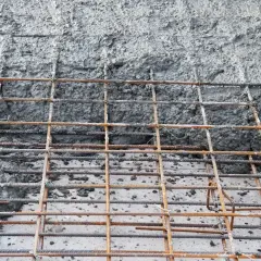Siatka zbrojeniowa, na której widać świeży, mokry beton. To właśnie chudziak, podstawa konstrukcji.