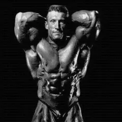 Dorian Yates prezentuje imponującą muskulaturę, dowód ciężkiego treningu.