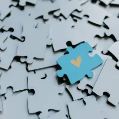 Niebieski element z sercem pośród białych puzzli. Jak oprawić puzzle, by stworzyć wyjątkową pamiątkę?