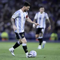 Lionel Messi w koszulce Argentyny prowadzi piłkę. Jego wzrost nie przeszkadza mu w byciu jednym z najlepszych piłkarzy świata.