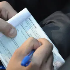 Ręka pisze mandat karny. Zastanawiasz się, ile czasu na zapłacenie mandatu? Dokument zawiera informacje o kwocie i terminie.