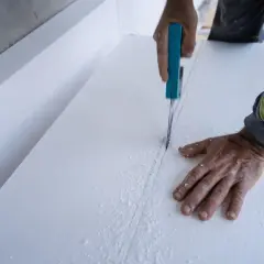 Ręce tną styropian, materiał budowlany. Czy styropian jest toksyczny? Pytanie o bezpieczeństwo materiału.