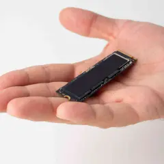 Dłoń trzyma mały dysk SSD M.2. Jego obecność zapewnia szybkie działanie systemu i optymalizację dzięki funkcji ssd trim.