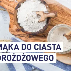 Mąka w drewnianej misce i zakwas w słoiku, obok kłosów zboża.