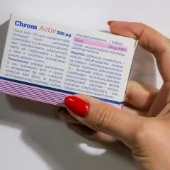 Dłoń trzyma opakowanie suplementu diety Chrom Activ 200 µg, który zawiera chrom.